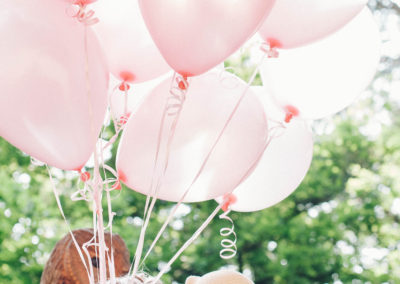 mother and daughter kissing with big bunch of pink balloons