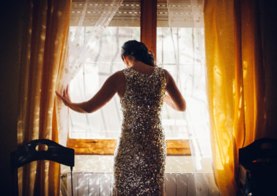 bride opening the curtain in sunlight