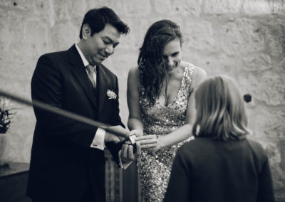 bride and groom recieving rings from a little girl