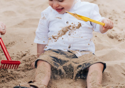 little boy playing in the sand on formally beach