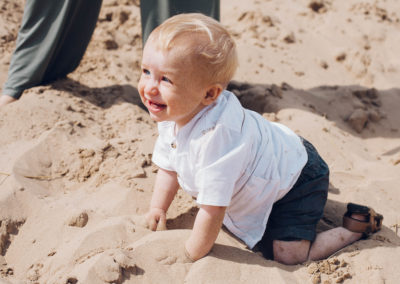 toddler crawling in the sand on the beach