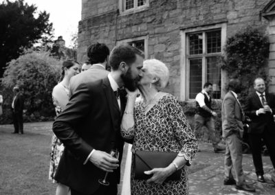 grandmother giving groom a kiss