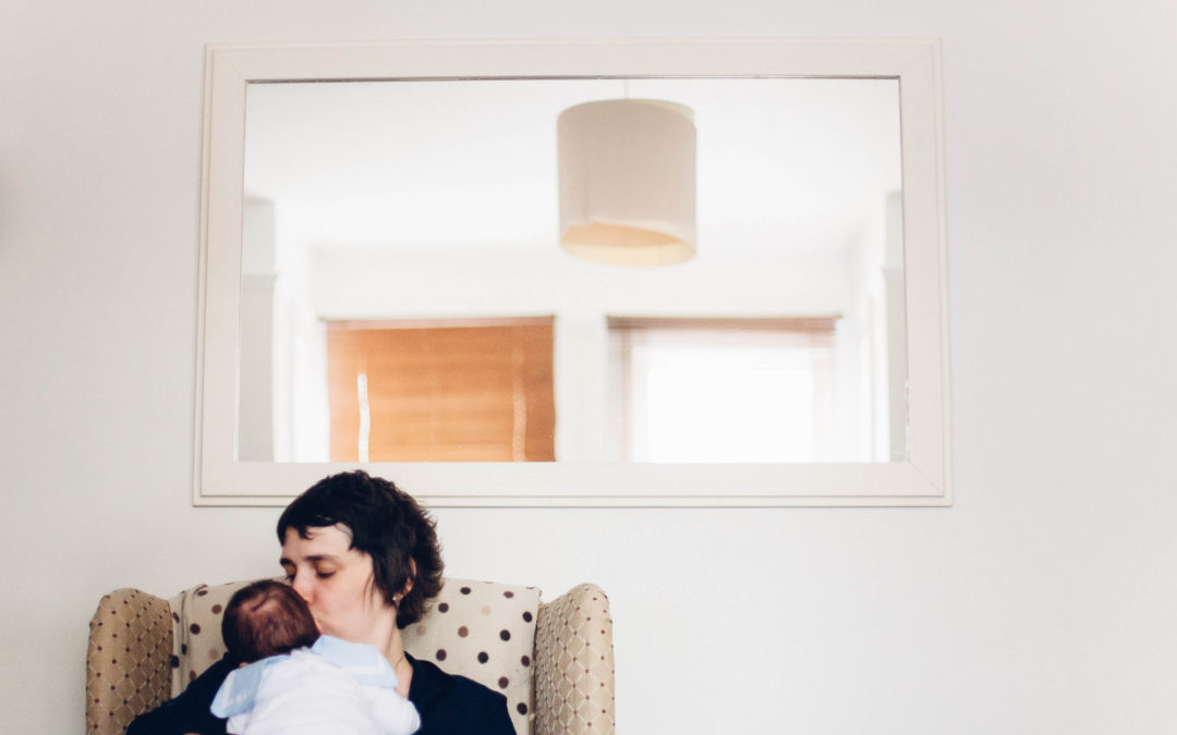 mother kissing baby sitting in living room